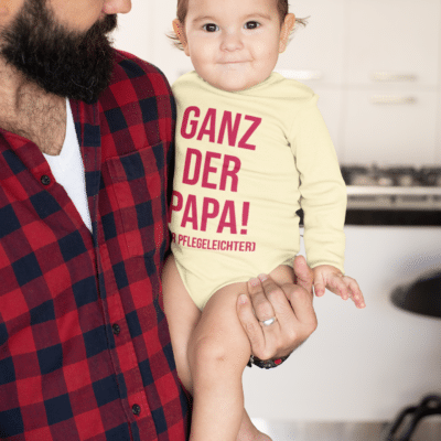 Ein Baby mit einem Body mit dem Druck Ganz der Papa