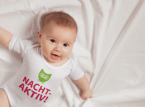 Ein Baby mit einem Body mit dem Druck Nachtaktiv